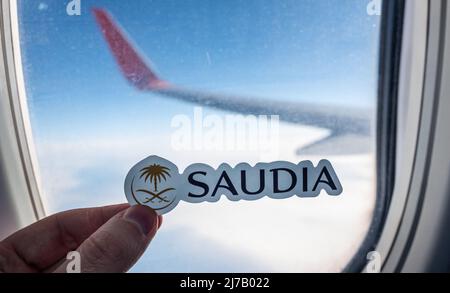 6. Dezember 2021, Jeddah, Saudi-Arabien. Das Emblem der Fluggesellschaft Saudia auf dem Hintergrund des Fensters des Flugzeugs. Stockfoto