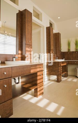 Modern sein und ihr eigenes Bad mit braunen Holz Eitelkeiten im luxuriösen Zuhause. Stockfoto