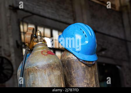 Nahaufnahme von Gasflaschen in einer verlassenen industriellen Produktionswerkstatt Stockfoto