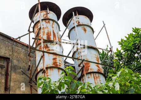 Nahaufnahme von Destillations- und Kühltürmen in einem alten Industriegebiet Stockfoto