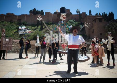 Ein Protestant (C), der mit einem traditionellen Kostüm bekleidet ist, singt Slogans, während andere eine riesige Marionette in einer Demonstration zur Unterstützung von „La Casa Invisible“ in der Innenstadt halten. Die Bewohner des 'Unsichtbaren Hauses', eines seit 2007 besetzten sozialen und kulturellen Zentrums, stehen kurz vor der Räumung nach einem langen Konflikt mit dem Rathaus von Malaga. Das "unsichtbare Haus" wurde in der Innenstadt von Malaga als soziales, kulturelles und alternatives Zentrum von lokalen Künstlern gegründet. Stockfoto