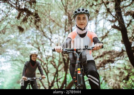 Junge muslimische Frau mit Sportbekleidung und Fahrradhelm Stockfoto