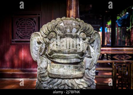 Eine Löwenskulptur sitzt vor einem Gebäude am Marble Mountain in Da Nang. Stockfoto