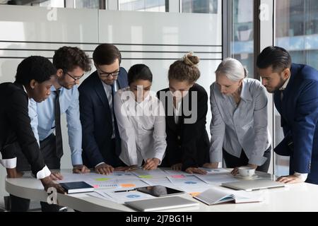 Treffen eines multiethnischen Geschäftsteams über Projektmarketingberichte Stockfoto