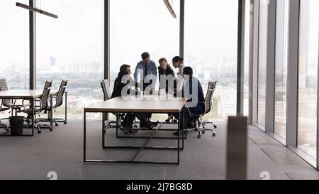 Ein vielseitiges, tausendjähriges Geschäftsteam an einem modernen Bürokonferenztisch Stockfoto