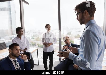 Seriöser junger Coach, der ein vielfältiges junges Business-Team ausbilden kann Stockfoto