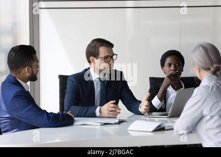 Eine vielfältige Gruppe seriöser Geschäftspartner, die über einen Deal verhandeln Stockfoto