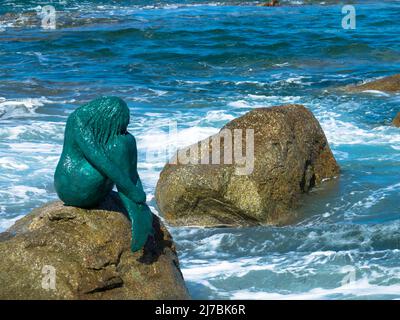 Bronze Meerjungfrau Skulptur genannt Sirenella di L'Isula Rossa sitzt auf einem Felsen im Mittelmeer. Ile Rousse, Korsika, Frankreich. 24. September 2020 Stockfoto