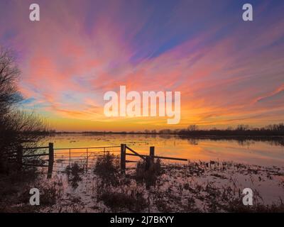 Dramatischer Abendhimmel nach Sonnenuntergang über der Ouse wäscht im Winter Flut, Sutton Gault, Cambridgeshire Stockfoto