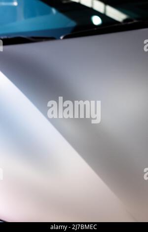 Nahaufnahme der Motorhaube eines modernen Autos mit Kurven auf matter Oberfläche Stockfoto