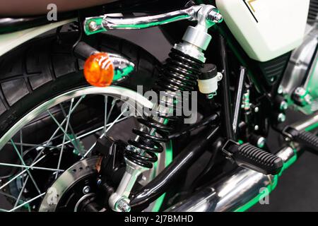 Detail der Fahrwerksfedern und Blinker am Hinterrad eines Custom Motorrads Stockfoto