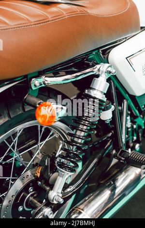 Detail der Fahrwerksfedern und Blinker am Hinterrad eines Custom Motorrads Stockfoto