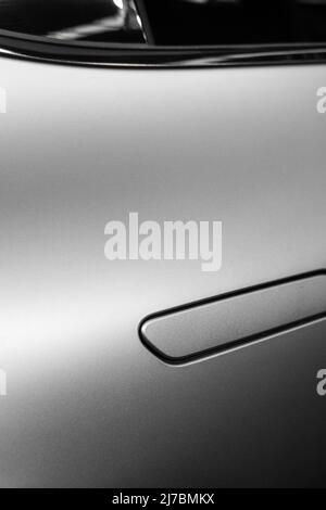 Mattgraue Metallic-Struktur mit Biegungen und schwarzen Kunststoffdetails und Gravuren Stockfoto