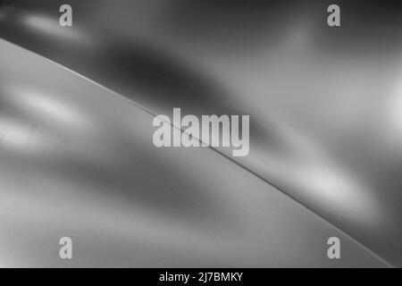 Matt metallische Struktur aus Stahl mit einer diagonalen Biegung und Reflexionen Stockfoto