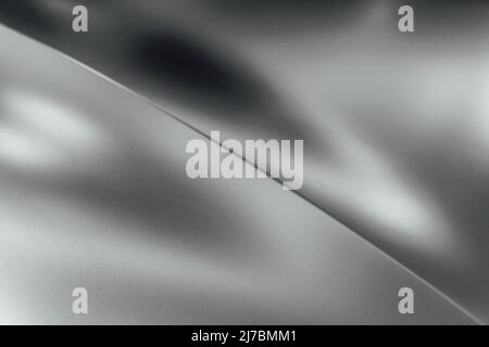 Silberfarbene matte Metallic-Textur mit diagonaler Biegung und Reflexionen Stockfoto