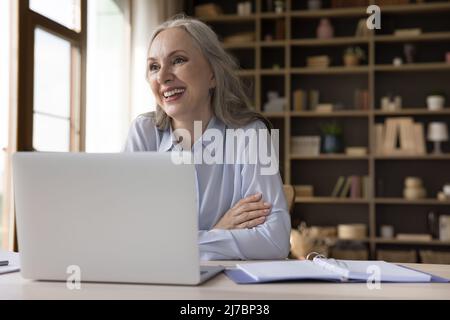 Fröhliche, fröhliche Geschäftsfrau, die gerne von zu Hause aus arbeitet Stockfoto