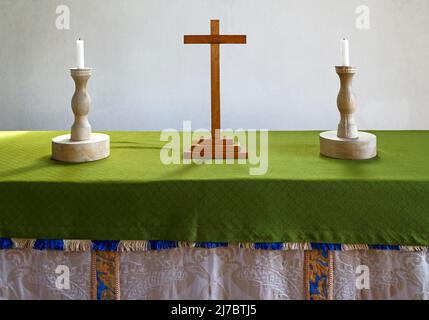 Zwei hölzerne Kerzenständer und ein Holzkreuz auf dem Altartisch in der St. Andreas-Kirche in Lamas, Buxton mit Lamas, Norfolk, England, Großbritannien. Stockfoto