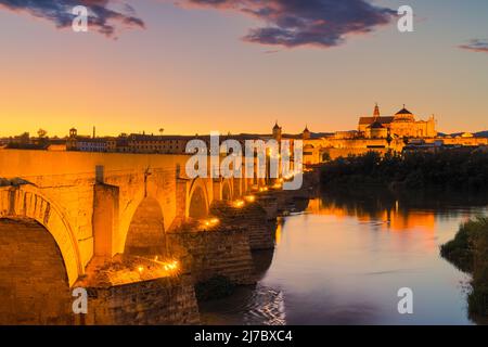 Ein Abend an der alten römischen Brücke in Cordoba. Im Hintergrund die große Moschee von Cordoba (Mezquita). Aufgenommen in der Stadt Cordoba, Andalusien, in t Stockfoto
