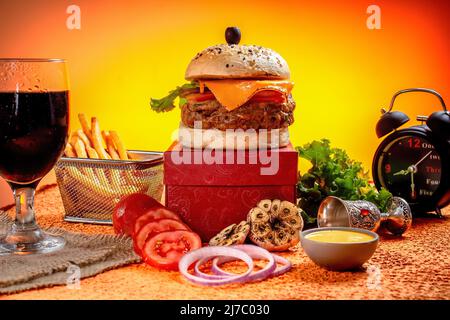 Tongue Twister Beef Naga Burger mit Pommes Frites und Tomatenscheibe isoliert auf Holzbrett Seitenansicht der amerikanischen Street Food Stockfoto