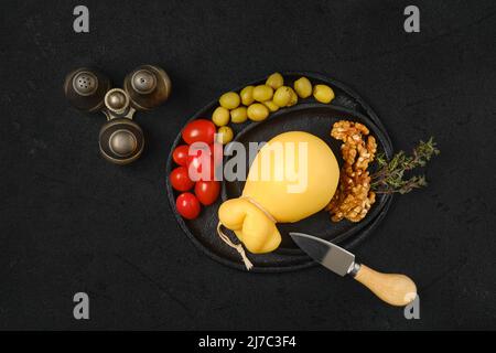 Blick von oben auf gezogenen gelben Caciocavallo-Käse auf einem Teller Stockfoto