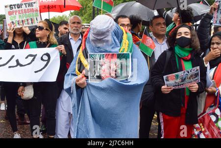 London, Großbritannien. 21.. August 2021. Eine Frau trägt eine Burka aus Protest gegen Zwangsverhüllung während der Demonstration im Hyde Park. Demonstranten marschierten durch Central London, um gegen die Übernahme Afghanistans durch die Taliban und den Umgang mit der Situation im Land durch das Vereinigte Königreich und die USA zu protestieren und die britische Regierung aufzufordern, Sanktionen gegen Pakistan zu verhängen und der Bevölkerung Afghanistans zu helfen. Stockfoto