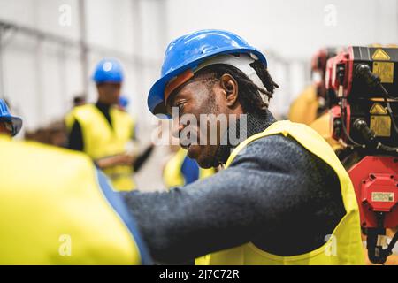 Ingenieure, die in der Roboterfabrik arbeiten - Industrie- und Technologiekonzept - Schwerpunkt auf dem menschlichen Ohr Stockfoto