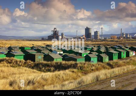 Fisherman's Huts mit Redcar Steelworks im Hintergrund. South Gare, Redcar, Teesside, North Yorkshire, England, VEREINIGTES KÖNIGREICH. Stockfoto