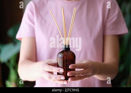 Frau hält ein Glas mit einem aromatischen Duft von hausgemachtem Duft in den Händen Stockfoto