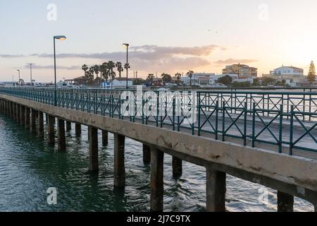 Faro, Portugal - 23. April 2022: Blick auf die alte Brücke, die zur Insel Faro führt, und den Strand an der Algarve von Portugal Stockfoto