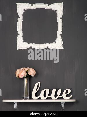 Weiße Rahmen auf Holzwand, Regal mit Vase und Blumen. Stockfoto