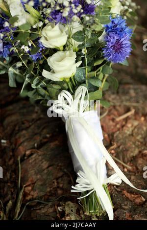 Hochzeitsstrauß aus Kornblumen und Rosen auf dem Baum. Stockfoto