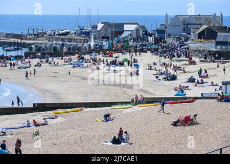 Lyme Regis, Dorset, Großbritannien. 8. Mai 2022. Wetter in Großbritannien: Urlauber und Sonnenanbeter strömen zum belebten Strand des Badeortes Lyme Regis, um heißen Sonnenschein und klaren blauen Himmel zu genießen, während die Hitzewelle im Mai anhält. Es wird nächste Woche mit Temperaturen von bis zu 26 Grad Celsius an der Südküste noch heißer werden. Kredit: Celia McMahon/Alamy Live Nachrichten. Stockfoto