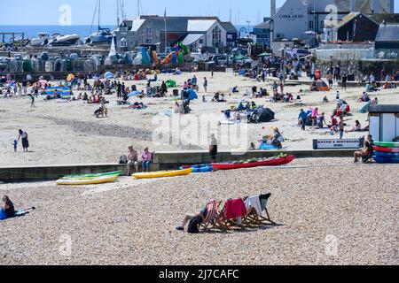 Lyme Regis, Dorset, Großbritannien. 8. Mai 2022. Wetter in Großbritannien: Urlauber und Sonnenanbeter strömen zum belebten Strand des Badeortes Lyme Regis, um heißen Sonnenschein und klaren blauen Himmel zu genießen, während die Hitzewelle im Mai anhält. Es wird nächste Woche mit Temperaturen von bis zu 26 Grad Celsius an der Südküste noch heißer werden. Kredit: Celia McMahon/Alamy Live Nachrichten. Stockfoto