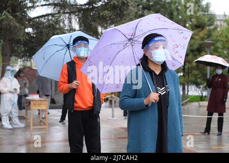 Xining, China. 08.. Mai 2022. (220508) -- XINING, 8. Mai 2022 (Xinhua) -- während eines regnerischen Tages im Bezirk Chengxi in Xining, nordwestlich der chinesischen Provinz Qinghai, stehen sich Menschen für Nukleinsäuretests an, 8. Mai 2022. (Xinhua/Zhou Shengsheng) Quelle: Xinhua/Alamy Live News Stockfoto