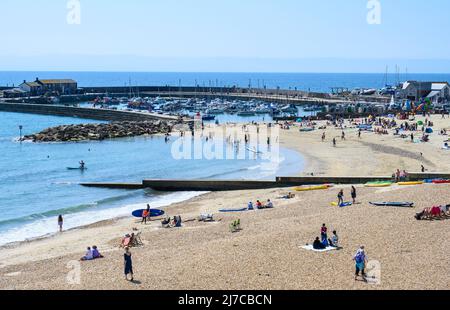 Lyme Regis, Dorset, Großbritannien. 8. Mai 2022. Wetter in Großbritannien: Urlauber und Sonnenanbeter strömen zum belebten Strand des Badeortes Lyme Regis, um heißen Sonnenschein und klaren blauen Himmel zu genießen, während die Hitzewelle im Mai anhält. Es wird nächste Woche mit Temperaturen von bis zu 26 Grad Celsius an der Südküste noch heißer werden. Kredit: Celia McMahon/Alamy Live Nachrichten. Stockfoto