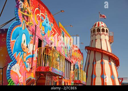 John-Henry Roper poliert das Crazy House unter blauem Himmel auf dem Messegelände an einem sonnigen Morgen in Hunstanton, Norfolk, Großbritannien, am 5. Mai 2022. Die Familie von Herrn Roper ist seit über 50 Jahren auf dem Messegelände. Stockfoto