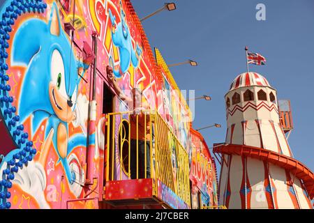 John-Henry Roper poliert das Crazy House unter blauem Himmel auf dem Messegelände an einem sonnigen Morgen in Hunstanton, Norfolk, Großbritannien, am 5. Mai 2022. Die Familie von Herrn Roper ist seit über 50 Jahren auf dem Messegelände. Stockfoto