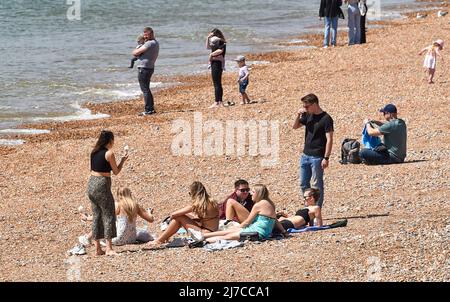 Brighton UK 8. May 2022 - Besucher genießen einen heißen, sonnigen Tag am Strand und am Meer von Brighton, da die Temperaturen in einigen Teilen Großbritanniens voraussichtlich über 20 Grad erreichen werden : Credit Simon Dack / Alamy Live News Stockfoto