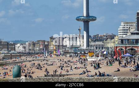 Brighton UK 8. May 2022 - Besucher genießen einen heißen, sonnigen Tag am Strand und am Meer von Brighton, da die Temperaturen in einigen Teilen Großbritanniens voraussichtlich über 20 Grad erreichen werden : Credit Simon Dack / Alamy Live News Stockfoto