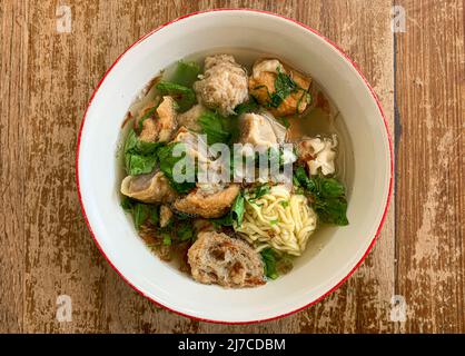 Eine Schüssel Fleischkugelsuppe mit frischem Gemüse auf dem alten Holztisch Stockfoto