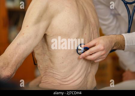 Ein Arzt überprüft die Gesundheit eines älteren männlichen Patienten mit Stethoskop. Stockfoto