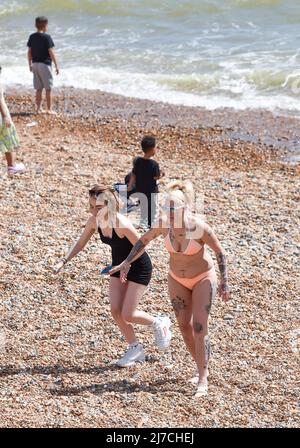 Brighton UK 8. May 2022 - Besucher genießen einen heißen, sonnigen Tag am Strand und am Meer von Brighton, da die Temperaturen in einigen Teilen Großbritanniens voraussichtlich über 20 Grad erreichen werden : Credit Simon Dack / Alamy Live News Stockfoto