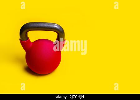 Kettlebell mit blauem Hintergrund gelber Textraum auf einem für isoliertes Eisen, zum Objektheben von schwarzem aus gesundem Fitnessstudio, Kettle Wellness. Wohlbefinden Stockfoto