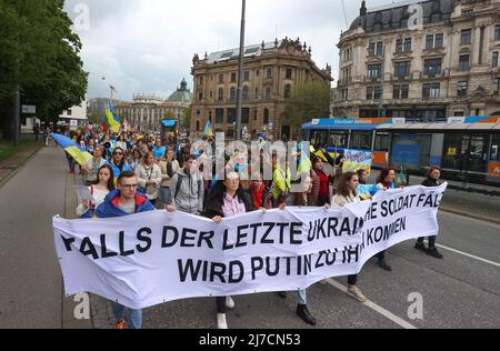 08. Mai 2022, Bayern, München: Teilnehmer einer Kundgebung gegen den Krieg in der Ukraine marschieren mit einem Transparent durch die Innenstadt mit der Aufschrift "Wenn der letzte ukrainische Soldat fällt. Putin wird zu Ihnen kommen.“ Foto: Karl-Josef Hildenbrand/dpa Stockfoto