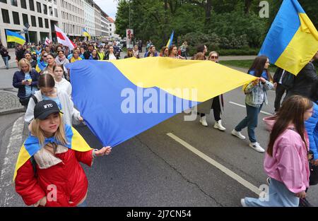 08. Mai 2022, Bayern, München: Teilnehmer einer Kundgebung gegen den Krieg in der Ukraine marschieren in einem Demonstrationszug mit ukrainischen Fahnen durch die Innenstadt. Foto: Karl-Josef Hildenbrand/dpa Stockfoto