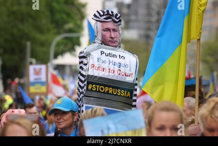 08. Mai 2022, Bayern, München: Ein Teilnehmer einer Kundgebung gegen den Krieg in der Ukraine hält ein Zeichen mit dem Bild Putins als Strafgefangenen und den Worten "Putin nach Den Haag, Putin vor Gericht" während eines marsches durch das Stadtzentrum. Foto: Karl-Josef Hildenbrand/dpa Stockfoto