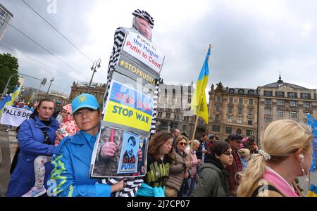 08. Mai 2022, Bayern, München: Ein Teilnehmer einer Kundgebung gegen den Krieg in der Ukraine hält ein Zeichen mit dem Bild Putins als Strafgefangenen und den Worten "Putin in Den Haag, Putin vor Gericht, Stop Putin, Stop war" während eines marsches durch das Stadtzentrum. Foto: Karl-Josef Hildenbrand/dpa Stockfoto