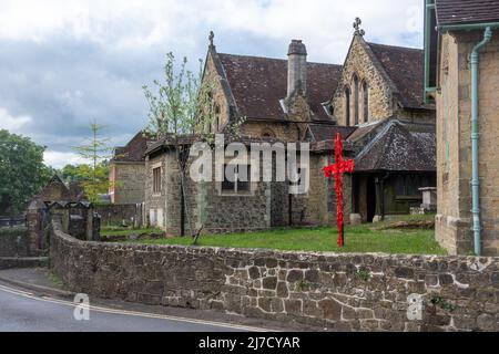 St. Bartholomew's Church in Haslemere, Surrey, England, Großbritannien, mit einem Kreuz, das zu Ostern mit roten Bändern geschmückt ist Stockfoto