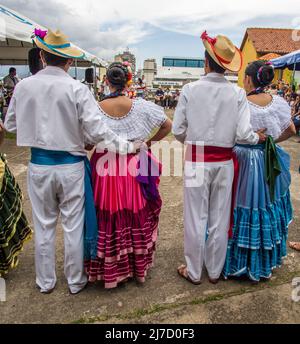 Rückansicht von vier Volkstänzern in traditioneller Kleidung, die an der Reihe sind, um in San José, Costa Rica, aufzutreten. Stockfoto