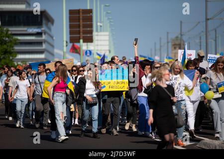 08. Mai 2022, Nordrhein-Westfalen, Köln: Teilnehmer der Friedensdemonstration „Solidarität mit der Ukraine“ gehen auf der Deutzer Brücke in Richtung Heumarkt mit Protestplakaten. Foto: Thomas Banneyer/dpa Stockfoto